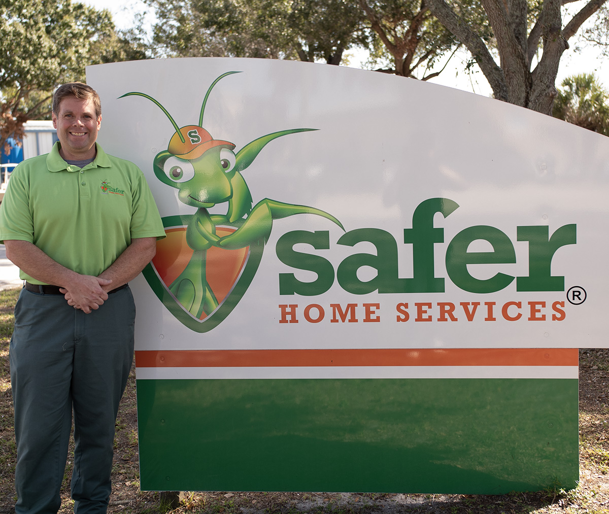 Man next to Safer Home Services sign